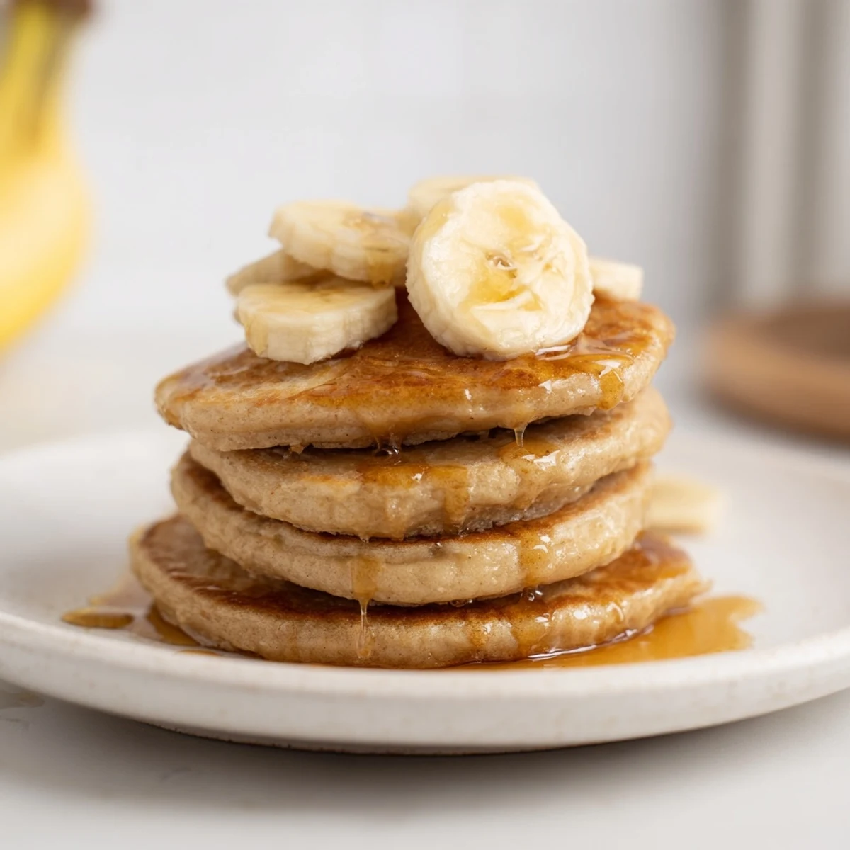 Golden-brunch banana pancakes, stacked high, drizzled with warm maple syrup, perfect for weekend breakfast.