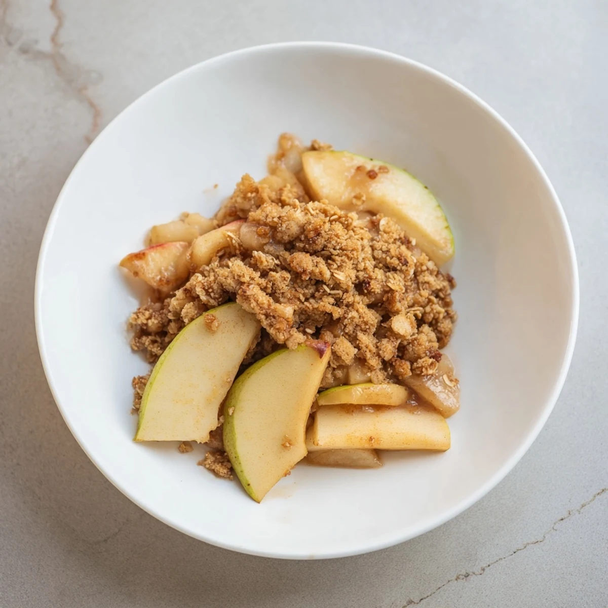 Warm Rustic Apple and Cinnamon Crumble, bubbling and golden brown, ready to serve with vanilla ice cream.