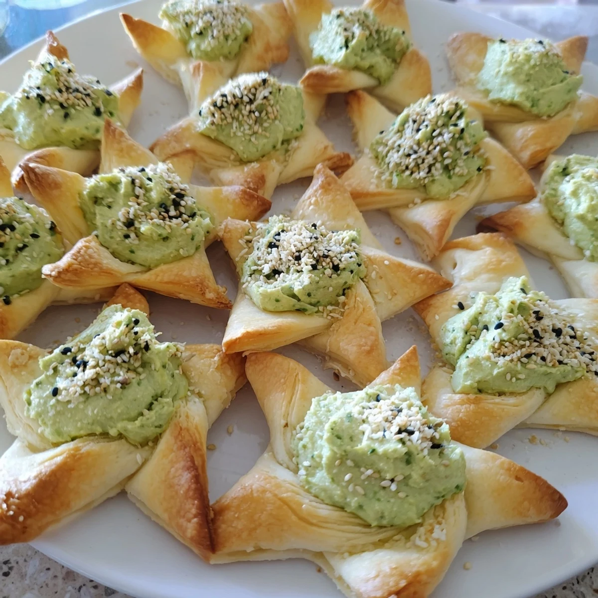 Creamy star-shaped pesto dip, the vibrant green filling surrounded by beautifully browned, crispy crackers.