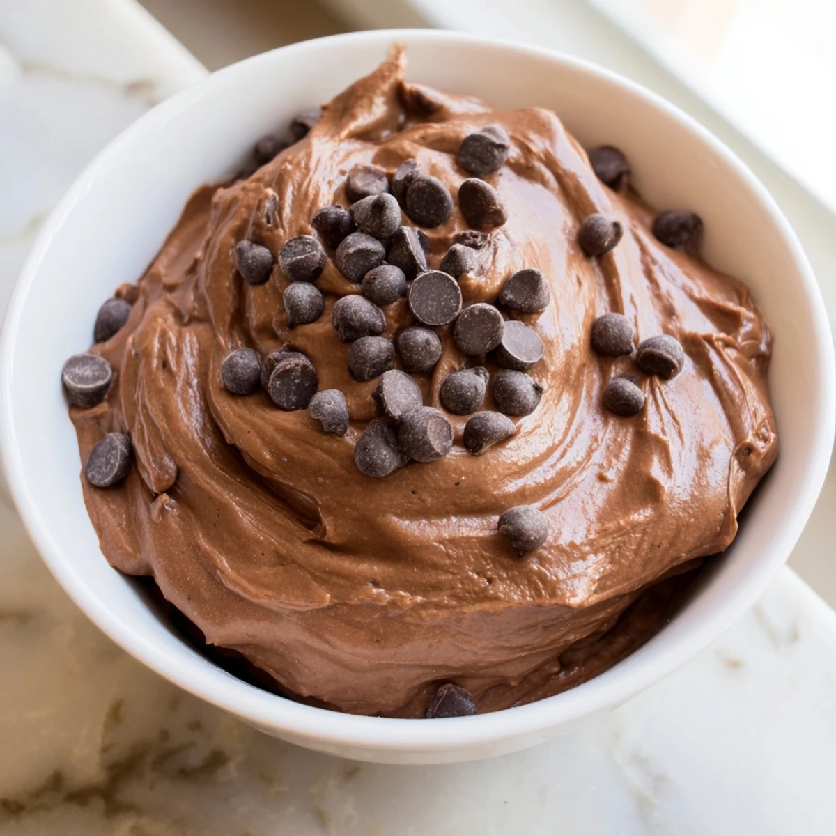 A close-up of a bowl filled with decadent brownie batter dip, ready to be enjoyed.