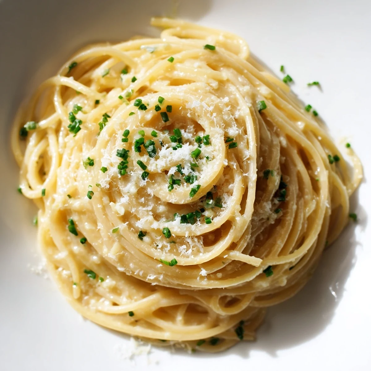 Close-up of creamy Miso Butter Pasta, showing garlic, fresh chives and a perfect, flavorful dish.
