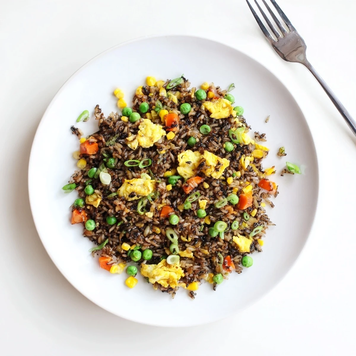 Steaming bowl of homemade Black Garlic Fried Rice featuring tender vegetables and fluffy grains for an easy weeknight dinner.  