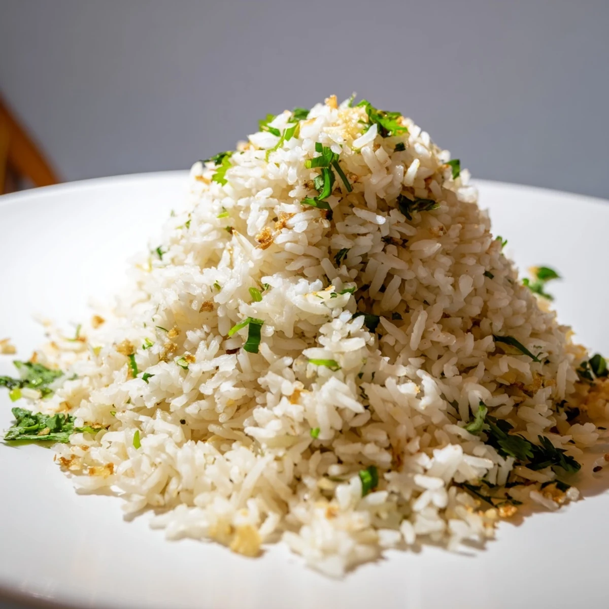A close-up of fragrant jasmine rice garlic, steaming and fluffy beside a stir-fry on a rustic table.  