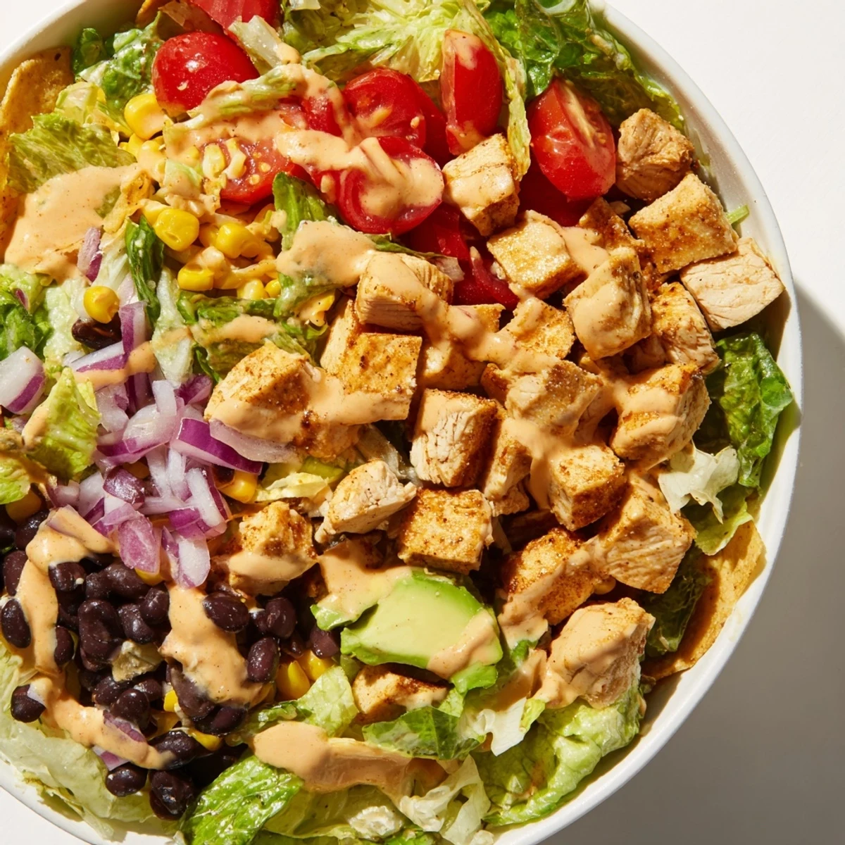 Ready-to-serve Chicken Taco Chopped Salad with colorful veggies, shredded cheese, and a drizzle of zesty lime salsa ranch.