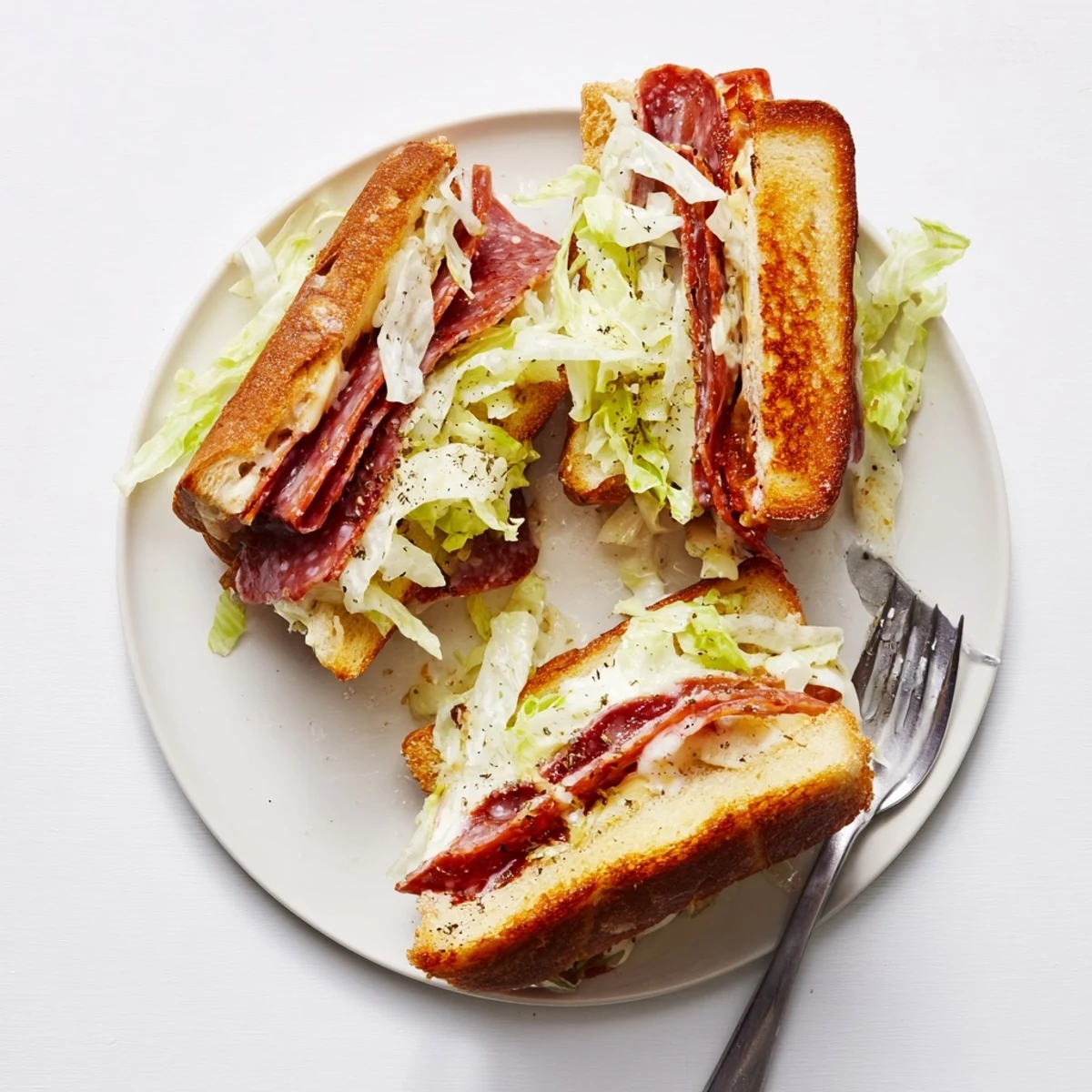 Close-up of an Italian Sub Grilled Cheese, revealing layers of meats and melted cheese inside.