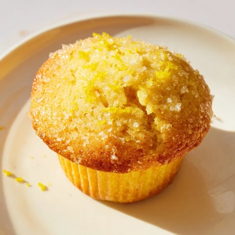 Golden-brown Simple Sweet Lemon Zest Muffins, perfectly domed, ready for a delightful brunch, with a hint of sparkling sugar.