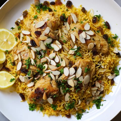 Golden saffron Chicken and Rice Pilaf with fluffy rice, tender chicken, and toasted almond garnish.