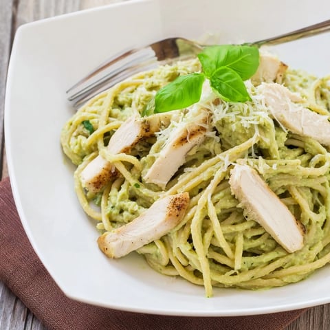 Creamy Avocado Chicken Pasta served in a white bowl, featuring silky avocado sauce coating linguine and topped with sliced grilled chicken.