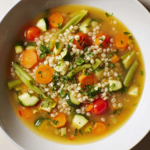Rustic serving of Simple Homemade Grain and Vegetable Soup, warm, with parsley garnish and lemon brightens it.