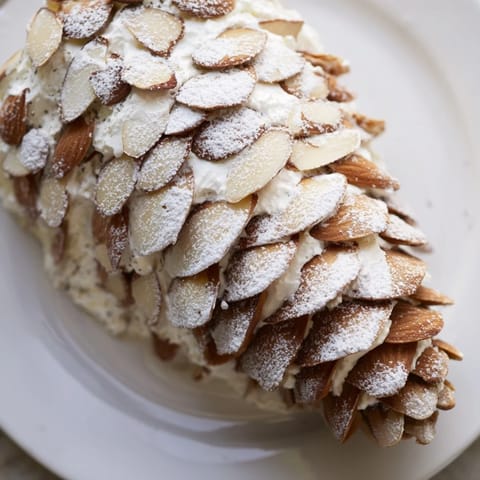 Delicate Snowy Pinecone Centerpiece with dusted powdered sugar, surrounded by green grapes and crackers, is ready.