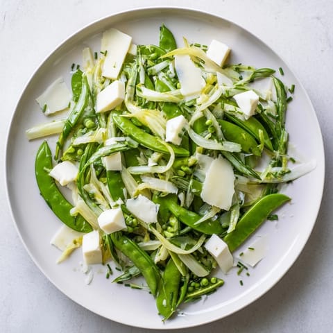 Freshly blanched snap peas and green beans intertwine in this English Ivy salad, a vegetarian delight.