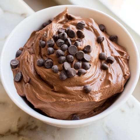 A close-up of a bowl filled with decadent brownie batter dip, ready to be enjoyed.