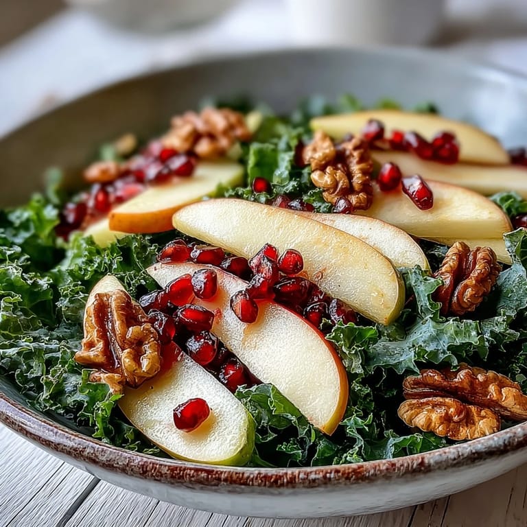 Healthy Kale and Pomegranate Bowl ready to serve, featuring crisp apples and chopped walnuts on vibrant greens.