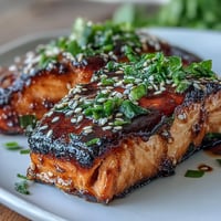 Succulent salmon fillets glazed with sweet-savory teriyaki sauce, oven-baked until tender and topped with toasted sesame seeds and fresh scallions.