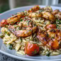 One-pan lemon butter shrimp and orzo with fresh vegetables in a zesty Mediterranean-inspired dinner.